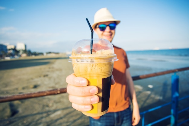 Man's and woman's hands close up holding frappe coffee cup.