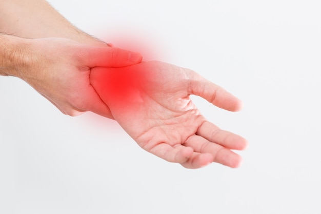 Photo man's wrist hurts. a damaged female hand hurts. hands suffer from work, sports injury. sore spot is highlighted in red. isolated white background.