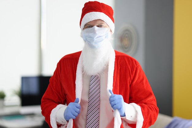 Man in santa claus costume and protective medical mask.