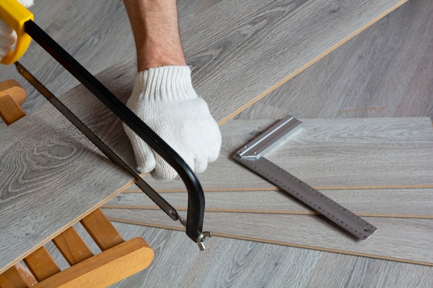 Man sawing gray laminate