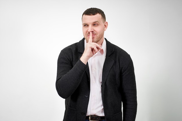 Man saying hush and be quiet with finger on lips gesture