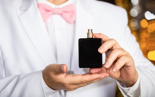 Man scent perfume. Perfume or cologne bottle. Fashion cologne bottle. Rich man prefers expensive fragrance smell. Fragrance smell. Male fragrance, perfumery, cosmetics. Smell perfume. Expensive suit.
