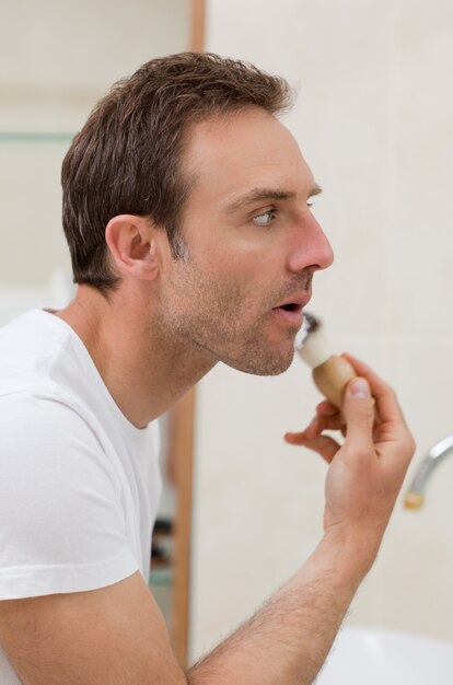 Man scheert in de badkamer