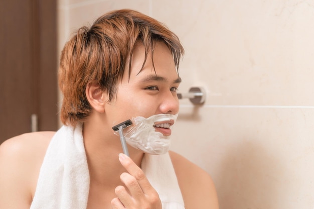 Man scheert in de badkamer