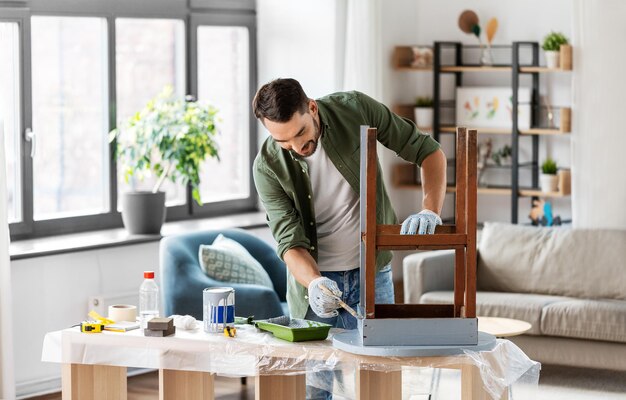 man schildert oude houten tafel in grijze kleur