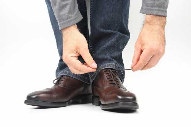 Man schoenveters binden op klassieke bruine schoenen