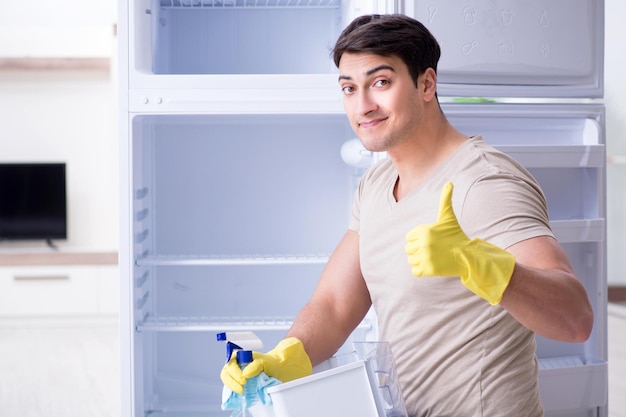 Man schoonmaak koelkast in hygiëneconcept