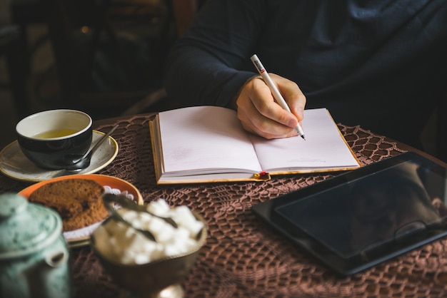 Man schrijven in een notitieblok in een café