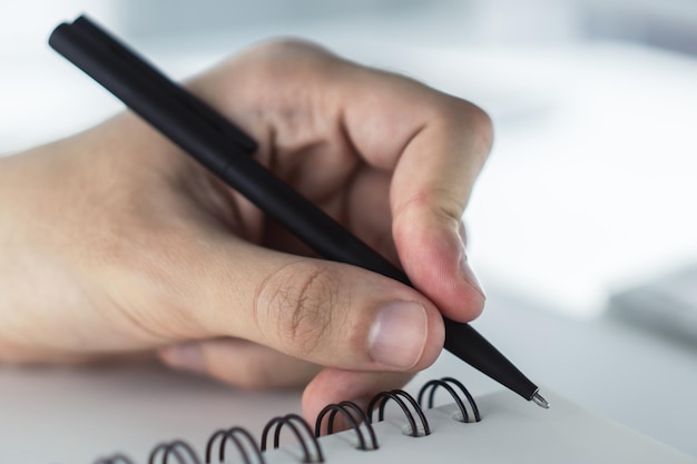 Man schrijven in kladblok Close-up Gericht op een hand met pen