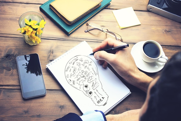 Man schrijven op idee papier op houten werktafel