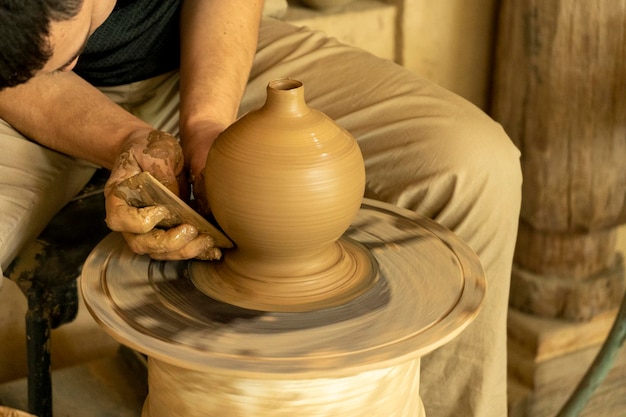 A man scraping the side part of the pot