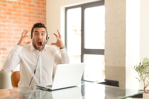 man screaming with hands up in the air, man feeling furious, frustrated, stressed and upset