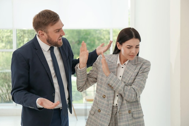 Foto uomo che urla alla donna in ufficio ambiente di lavoro tossico