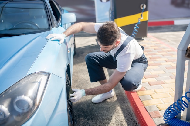 Man screwing cap of protective wheel nut