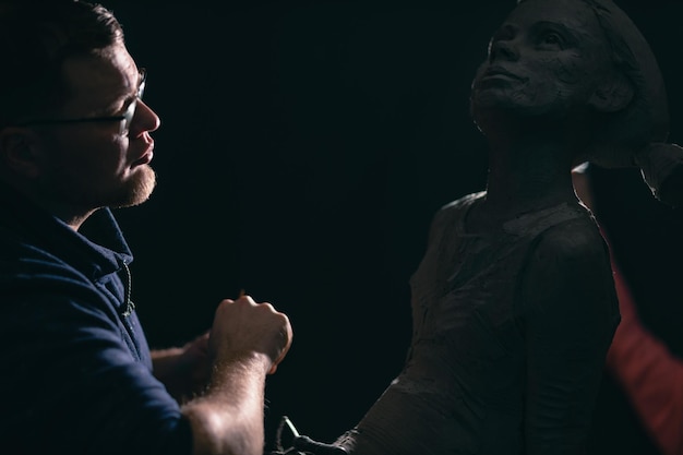 Foto scultore uomo crea scolpire busto argilla scultura donna umana statua laboratorio di creazione artigianale