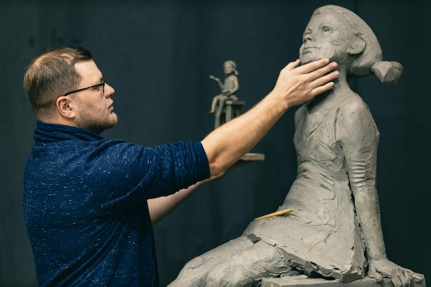 Scultore uomo crea scolpire busto argilla scultura donna umana statua laboratorio di creazione artigianale