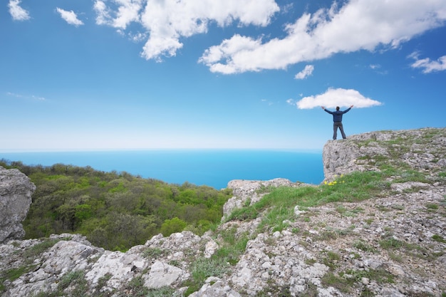 Man on sea cliff edge Conceptual and emotional scene