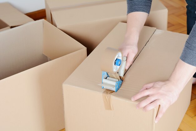 Man sealing a shipping cardboard box