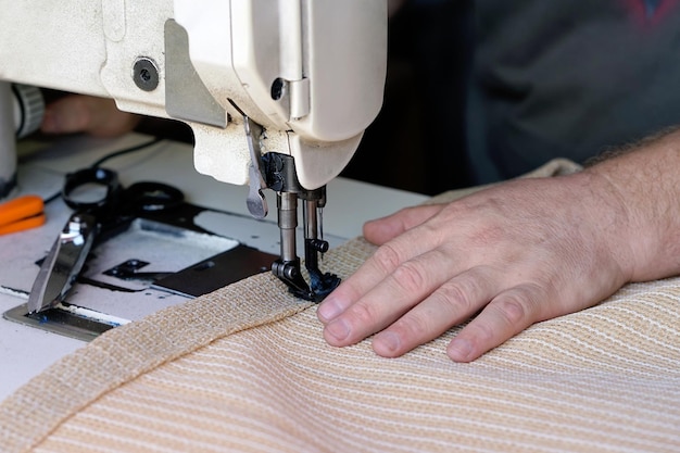 Man seamstress Men's hands behind sewing leather