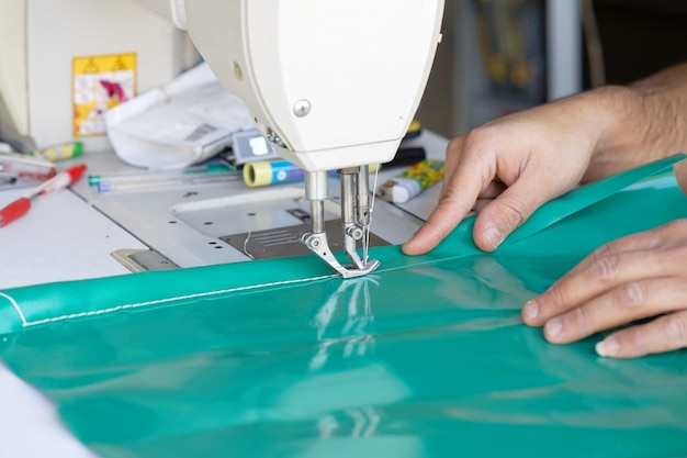 Man seamstress. men's hands behind sewing leather.