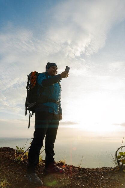 Man searching something on smartphone at mountain peak Swiping with hand on cellphone