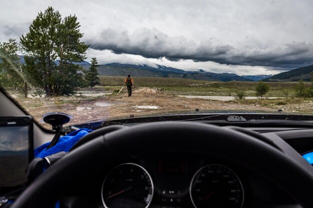 Man seen through car windshield against sky