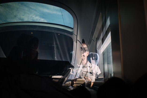 Photo man seen through glass traveling in train