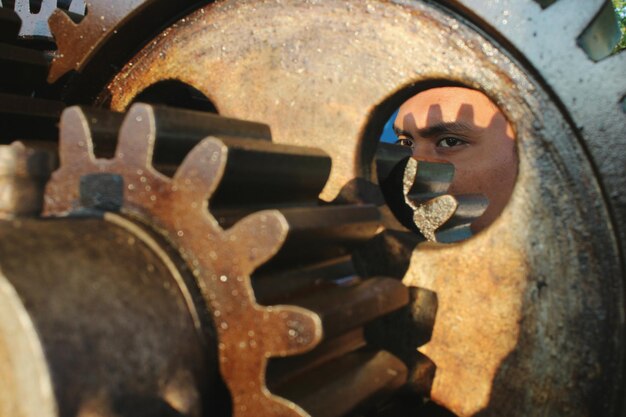 Foto l'uomo visto attraverso un buco di metallo