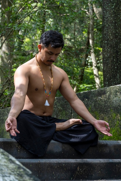 Man seen up close without shirt doing stretches on yoga mat exercise latin america