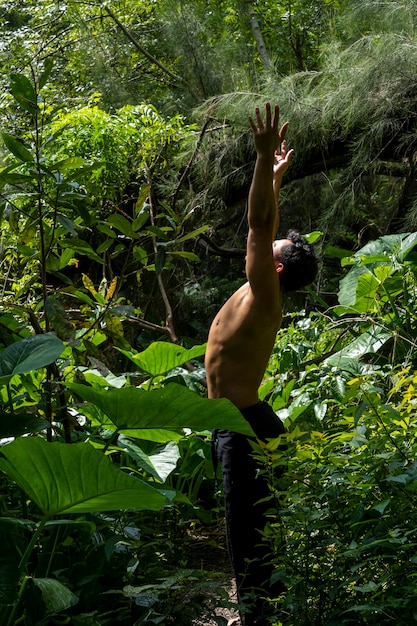 Man seen up close without shirt doing stretches on yoga mat exercise latin america