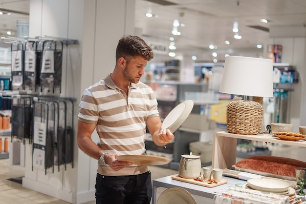 Man selecting plates in shop