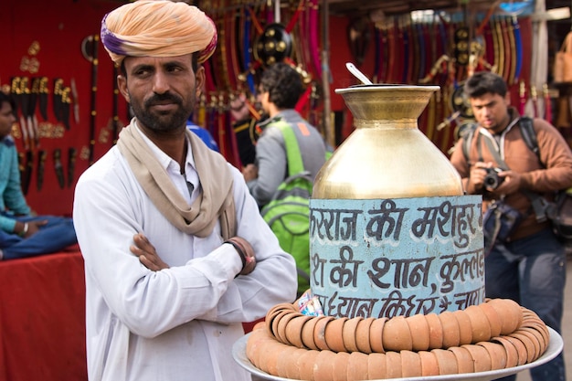 インドのプシュカルの町の通りでインドのマサラ ティー (チャイ ワラ) を売る男