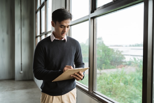 Man serious write on clipboard in the office room