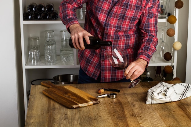 Man serveert een glas rode wijn