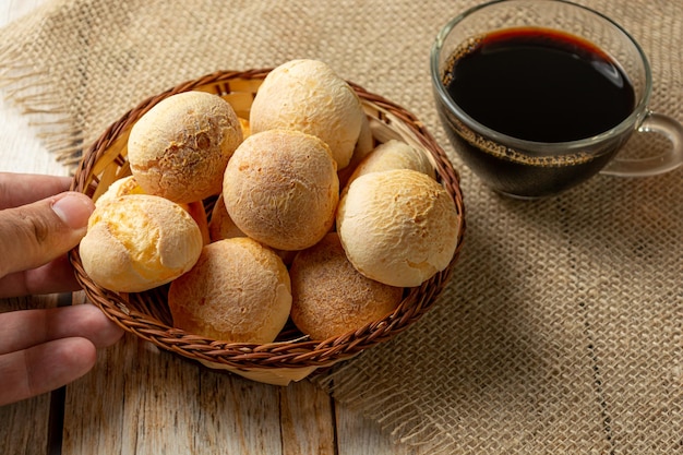 Man serves cheese bread on wooden table traditional brazilian meal concept with typical food