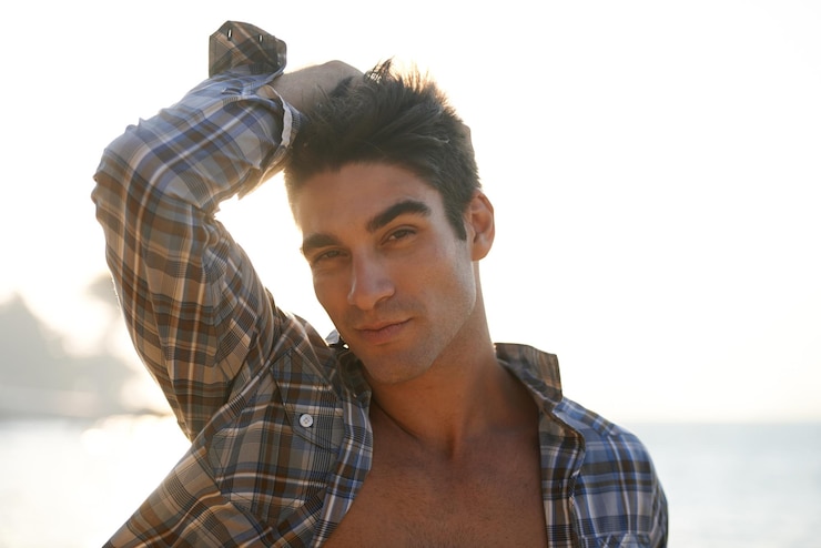 Photo man sexy and travel with fashion portrait and happiness in landscape confident and stylish male person beach and cool by ocean coast and tropical for summer vacation and pride in cape town