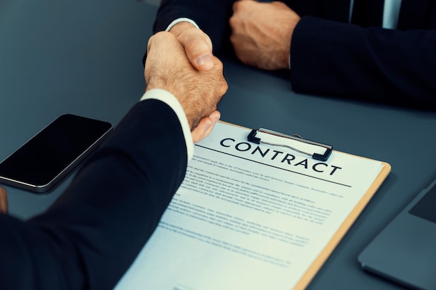 A man shaking hands over a contract.