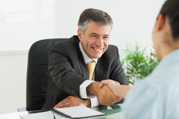 Man shaking a woman&#039;s hand in an office