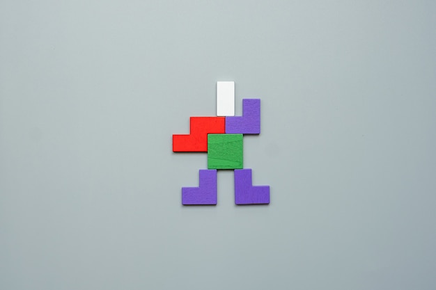 Man shape block of colorful wood puzzle piece on gray