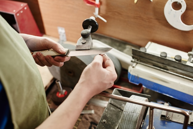 Man sharpening a knife in the workshop