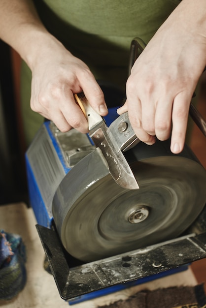 Man sharpening a knife in the workshop