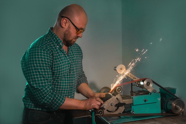 a man sharpens a knife on a special machine