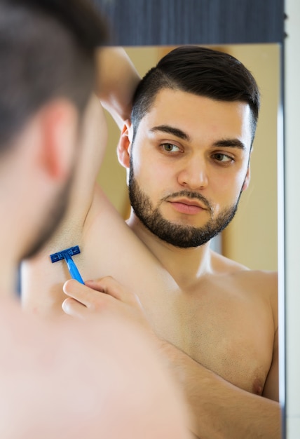 Man shaving armpit hair