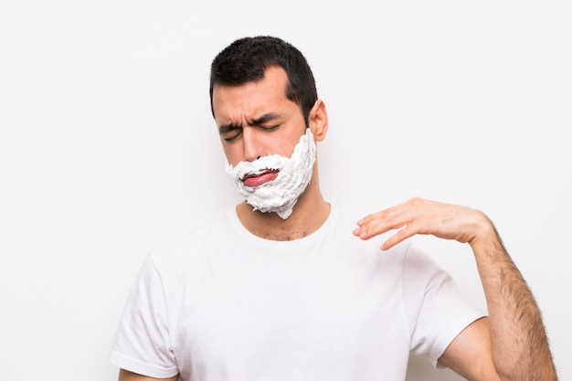 Man shaving his beard with tired and sick expression