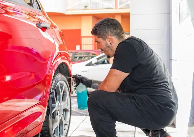 man shines car tires with a spray can