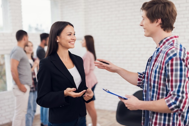 Man in shirt explaining some information to woman on tablet