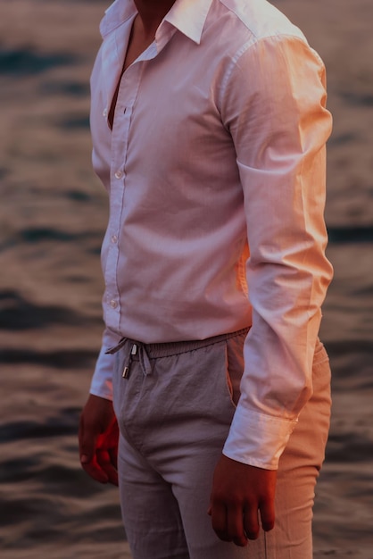 셔츠를 입은 남자가 바다 한가운데 서 있습니다. 고품질 사진