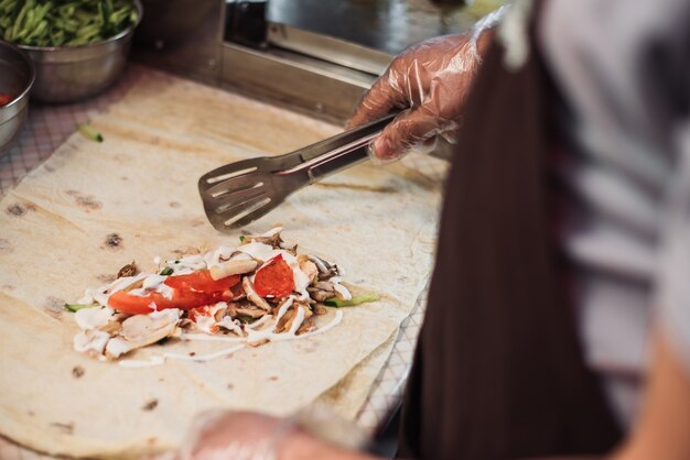 Man shoarma koken in pita in de keuken