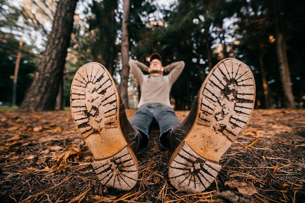 a man in  shoes with wooden sole sitting in autumn park