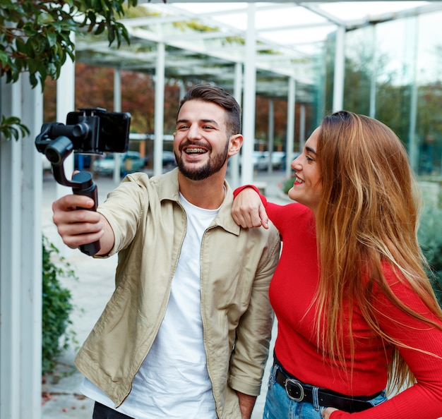 Man shooting a video with gimbal with woman